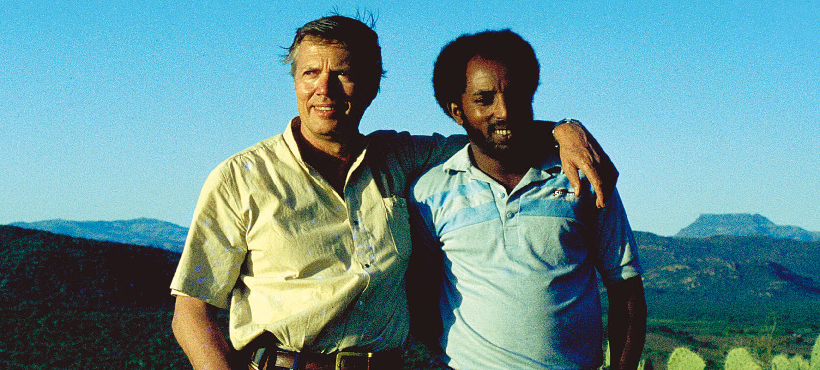 Karlheinz Böhm in Ethopia, arm in arm with a local friend. In the background is the beautiful landscape of ethopia