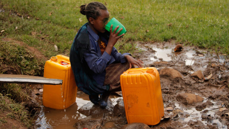 Girl drinks from a contaminated water point in the Jeldu contaminated waterhole