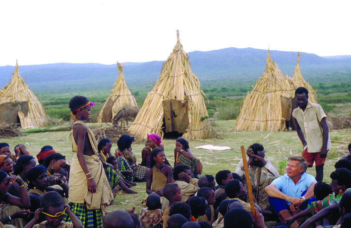 Karlheinz Böhm sits surrounded by Ethiopians