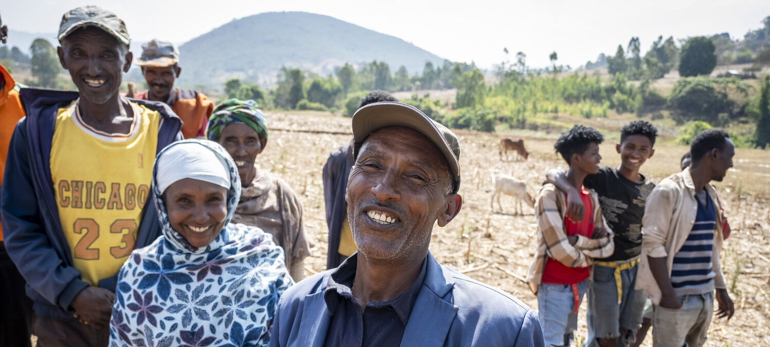 A group of people is standing outside on a field.