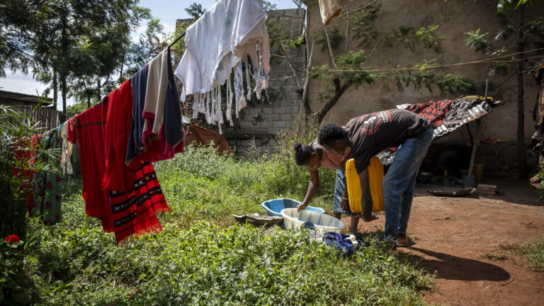 Meskerem Birhanu washing clothes in her garden.