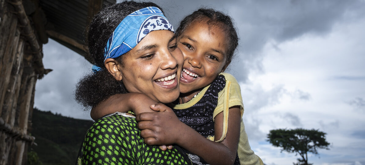 A girl hugging her mother.