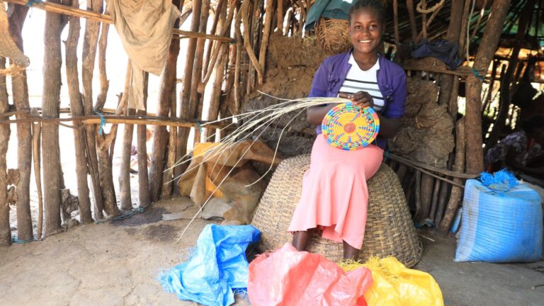 A young woman crafting Sefed, colorful art bowls made from wood fibers.
