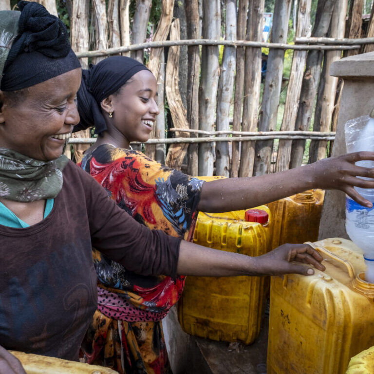Women draw water from a newly constructed spring