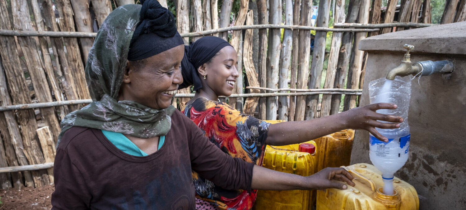 Women draw water from a newly constructed spring