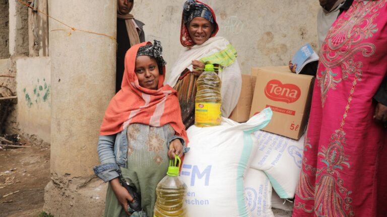 Two women standing infront of food ratio provided as emergency relief in IDP-Camp in Debre Birhan