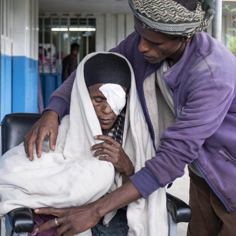 An elderly woman is receiving cataract treatment.