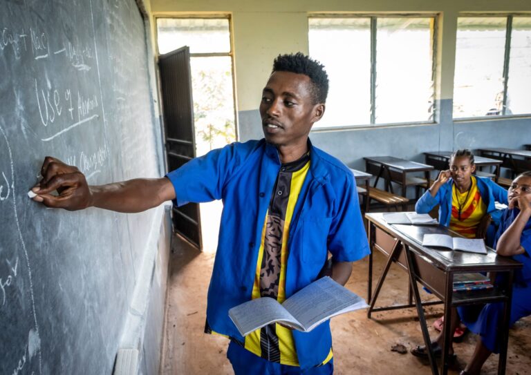 A young man, student, writing on the chalkboard