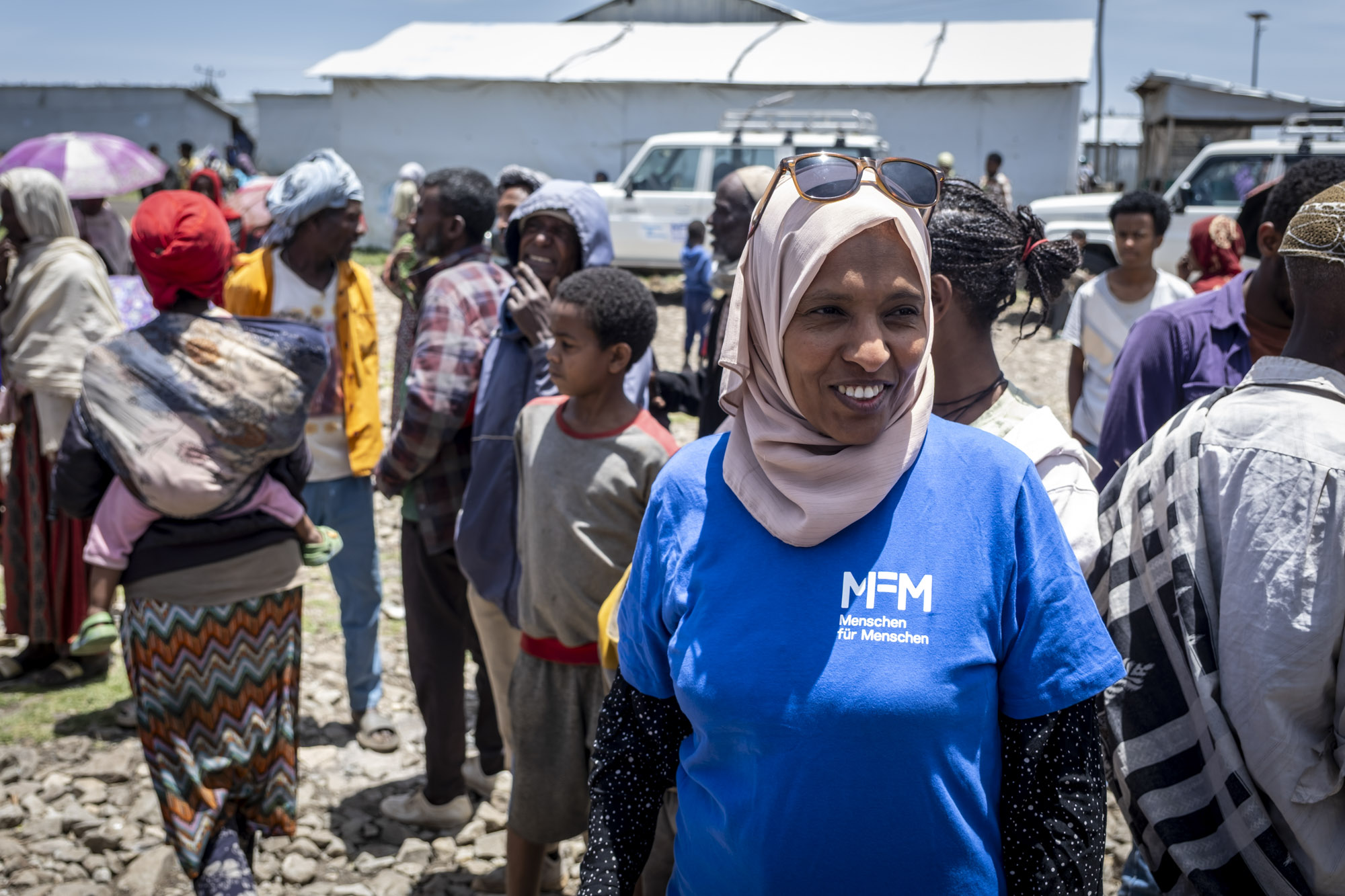 Woman wearing an MFM shirt in front of different people