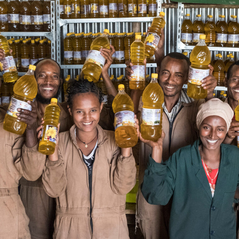 Group of people liftling bottles of oil